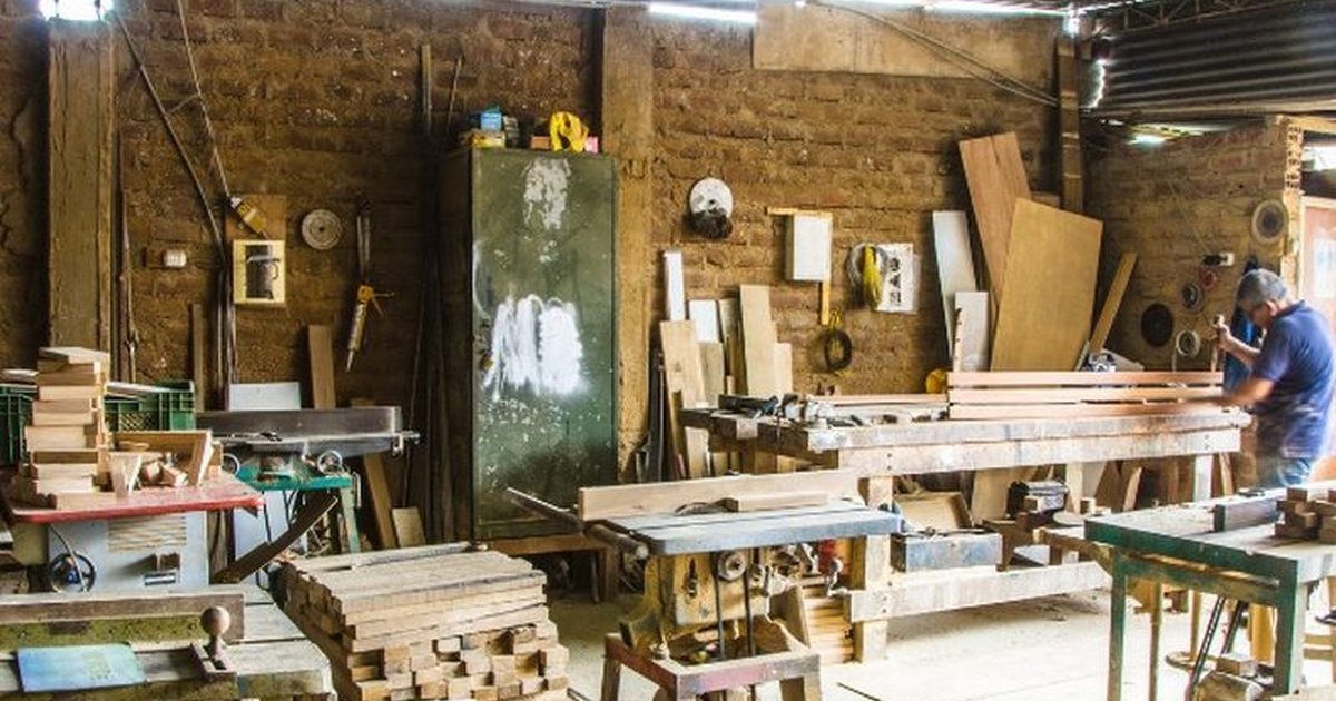 Carpintero midiendo con flexómetro y nivel el hueco de un armario empotrado en una vivienda de Soria