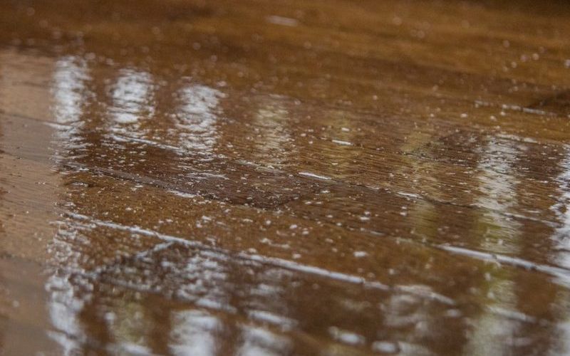 Superficie de madera barnizada con brillo y veta marcada