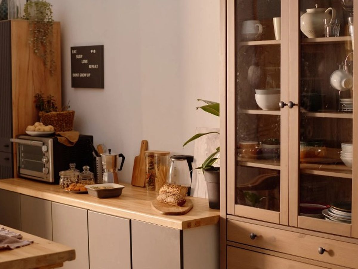 Cocina de madera a medida con vitrina y alacena en una casa tradicional de Almazán