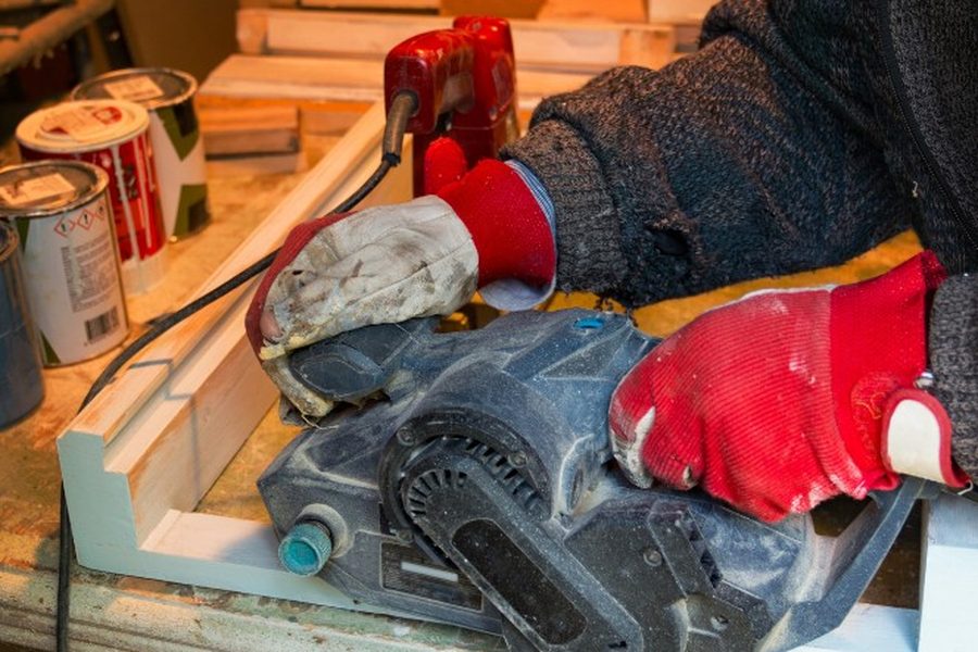 Lijado de un marco de madera en el taller de Soria antes de aplicar el lacado